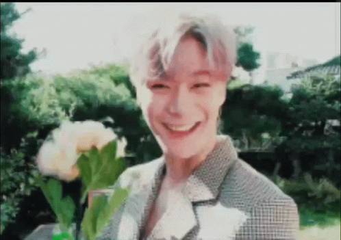 Young Man Smiling Holding Flowers GIF
