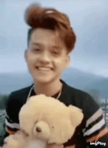 Young Man Smiling Holding Teddy Bear