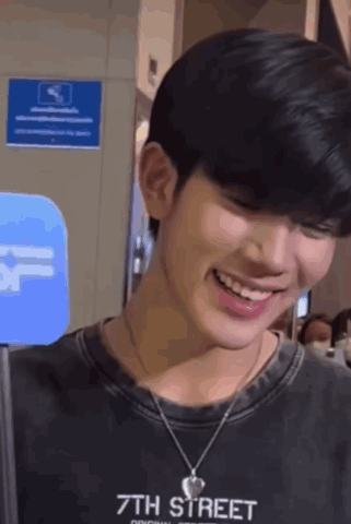 Young Man Smiling in Black 7th Street Shirt