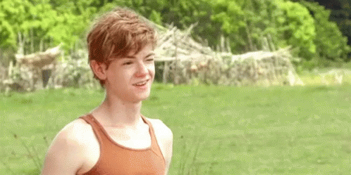 Young Man Smiling In Field In Tank Top GIF