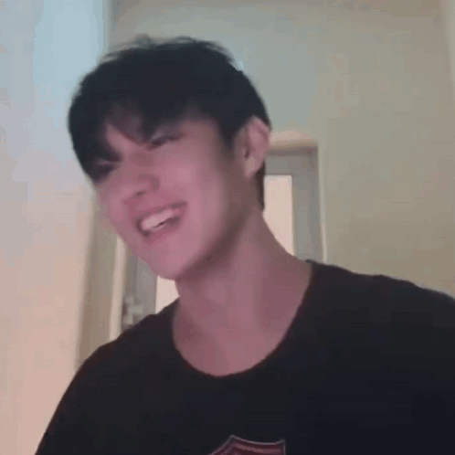 Young Man Smiling Making Funny Face In Black T-Shirt GIF