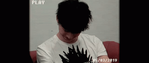 Young Man Smiling On Red Couch GIF