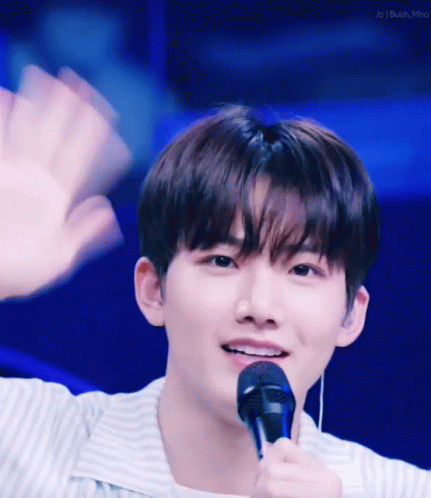 Young Man Waving and Smiling with Microphone