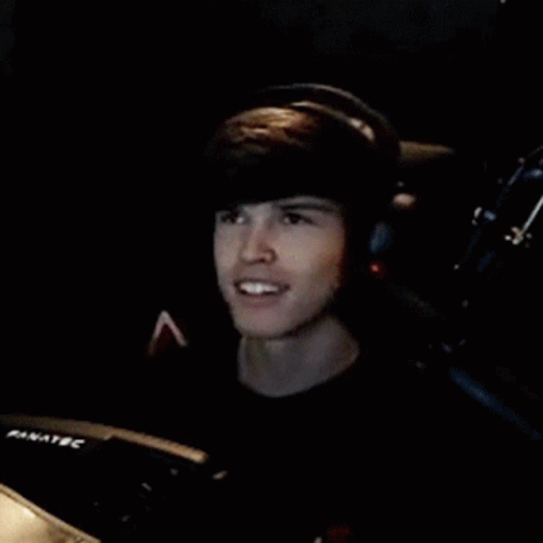 Young Man Wearing Headphones and Smiling in Chair
