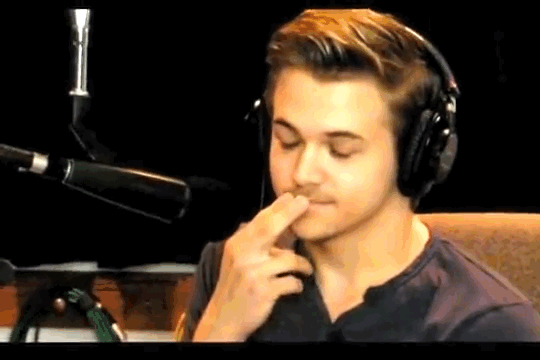Young Man Wearing Headphones Covering Mouth GIF