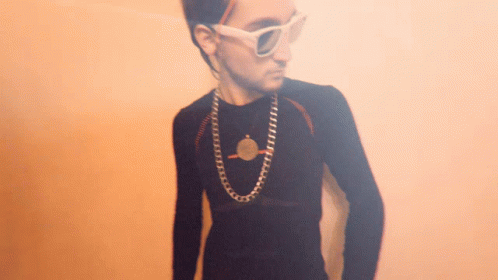 Young Man Wearing Sunglasses and Coin Necklace