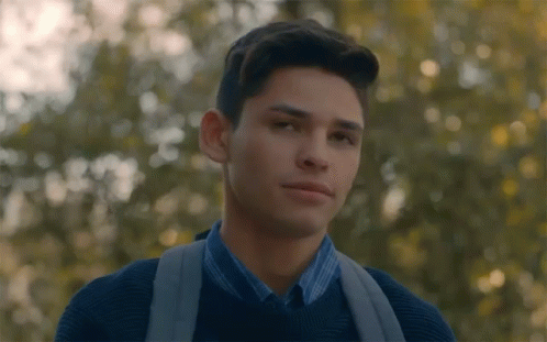 Young Man With Backpack Looking at Camera in Trees