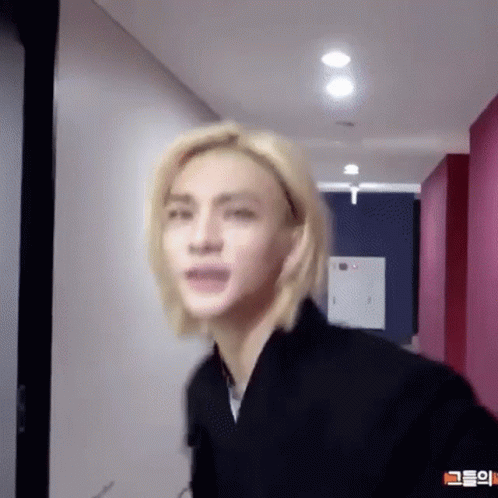 Young Man With Blonde Hair Standing in Hallway