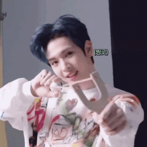 Young Man with Blue Hair Holding Small Object