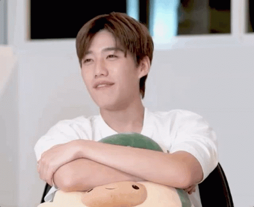 Young Man With Crossed Arms Holding Stuffed Animal