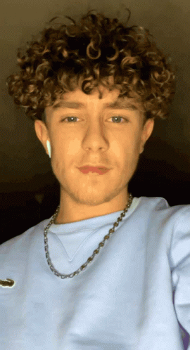 Young Man with Curly Hair and Necklace