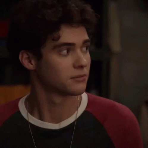 Young Man with Curly Hair in Black and Red Sweater