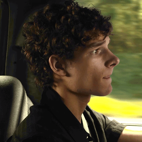 Young Man With Curly Hair in Driver's Seat
