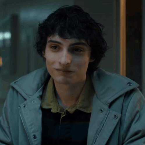Young Man with Curly Hair in Grey Hoodie
