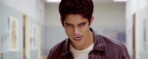 Young Man With Fangs Standing in Hallway Eyes Closed