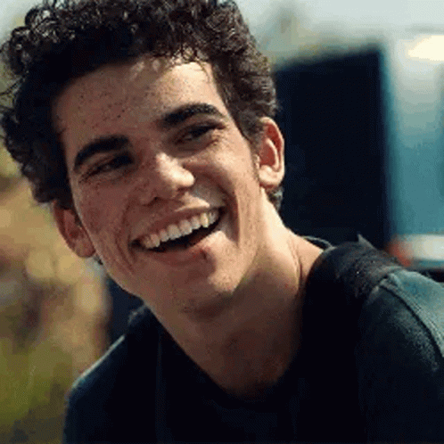 Young Man With Freckles Smiling in Black Shirt