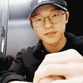 Young Man with Glasses and Hat Holding Hands