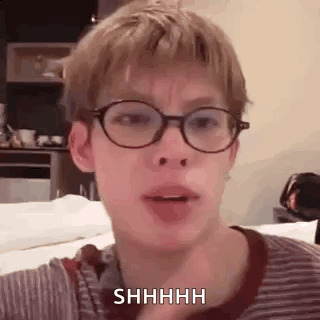 Young Man With Glasses And Striped Shirt Shushing GIF