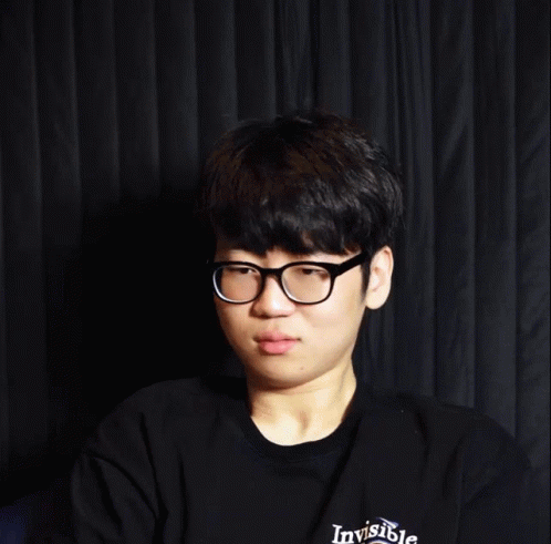 Young Man With Glasses Smiling Before Black Curtain