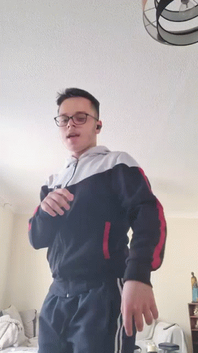 Young Man With Glasses Standing in Living Room