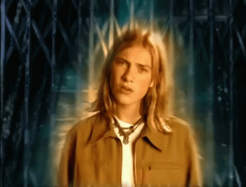 Young Man With Long Blonde Hair by Fence