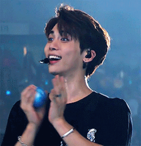 Young Man With Microphone and Bracelet Clapping
