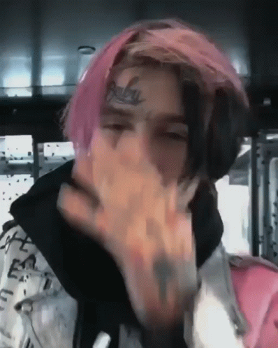 Young Man With Pink Hair and Face Tattoo Covering Mouth