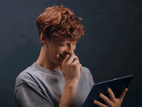 Young Man With Red Hair Laughing Holding Tablet GIF
