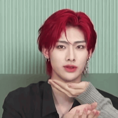 Young Man With Red Hair Sitting on Couch Hands on Neck
