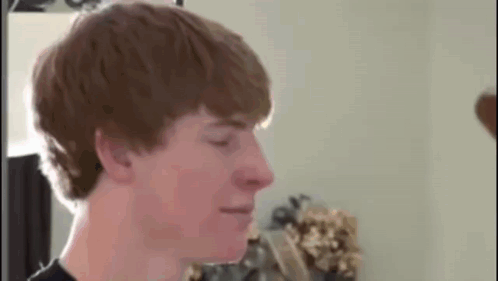 Young Man With Red Hair Standing In Front Of Mirror GIF