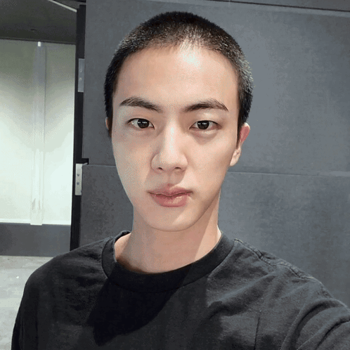 Young Man With Shaved Head Looking at Camera