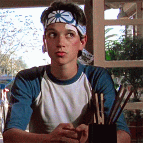 Young Man With Star Headband Sitting GIF