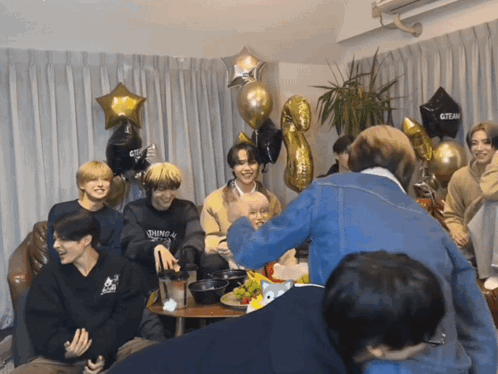 Young Men Around Table with Black Gteam Balloon