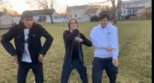 Young Men Dancing in Grassy Field