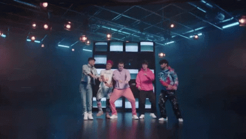 Young Men Dancing On Stage In Front Of TV Wall GIF