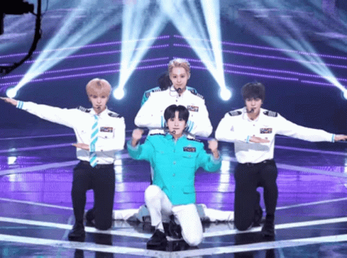 Young Men Performing on Stage With Blue Jacket Saying Captain