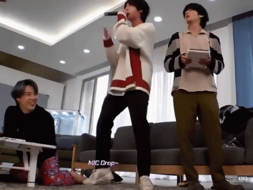 Young Men Standing Near Mic Drop Sign