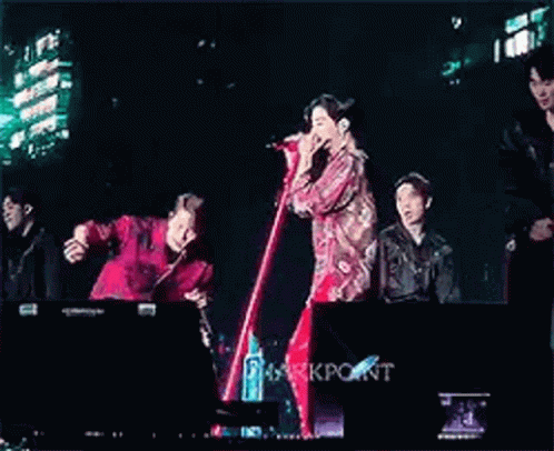 Young Men Standing on Stage With Microphones