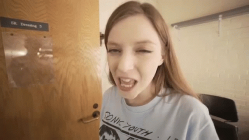 Young Woman in Blue Sonic Youth Shirt at Door