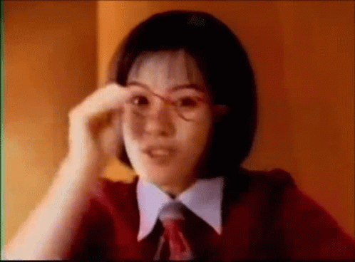 Young Woman in Glasses and Red Tie Adjusting Glasses