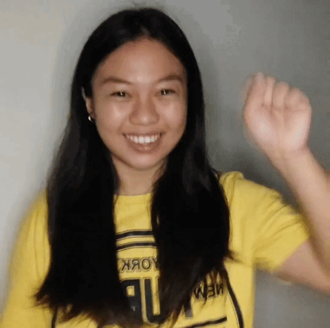 Young Woman in Yellow Shirt Saying New York