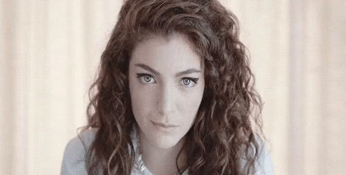 Young Woman With Curly Hair Looking At Camera GIF