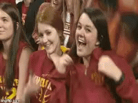 Young Women in Red Shirts Cheering in Stadium