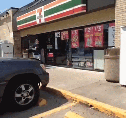 A 7 Eleven Store Front With A Car Parked In Front Of It GIF