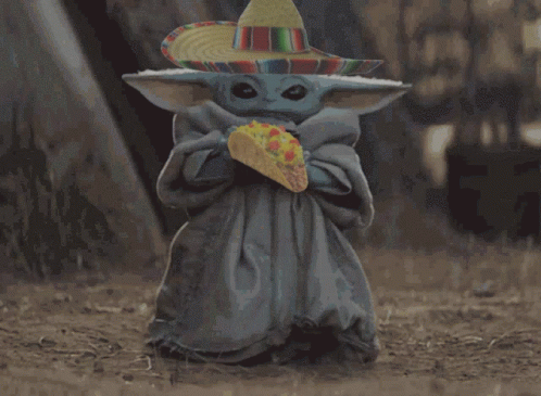 A Baby Alien Wearing A Sombrero Is Holding A Taco GIF