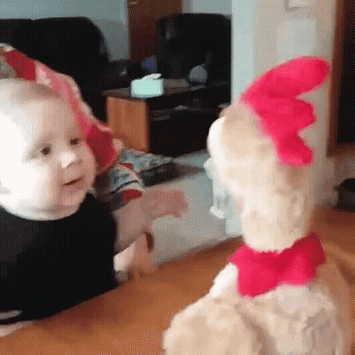 A Baby And A Stuffed Animal Are Looking At Each Other . GIF