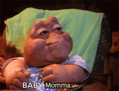 A Baby Dinosaur Says Baby Momma While Sitting In A Chair GIF