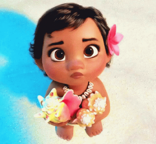 A Baby Doll With A Flower In Her Hair Holds Seashells GIF