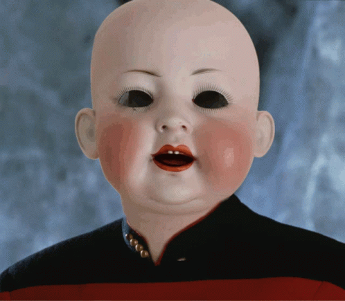A Baby Doll With Red Lips And Black Eyes Is Wearing A Black And Red Striped Shirt GIF
