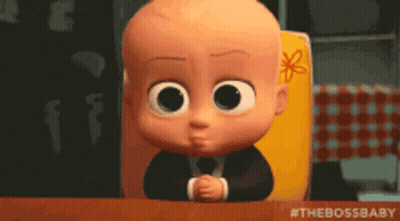A Baby From The Boss Baby Is Sitting At A Table With His Hands Folded GIF